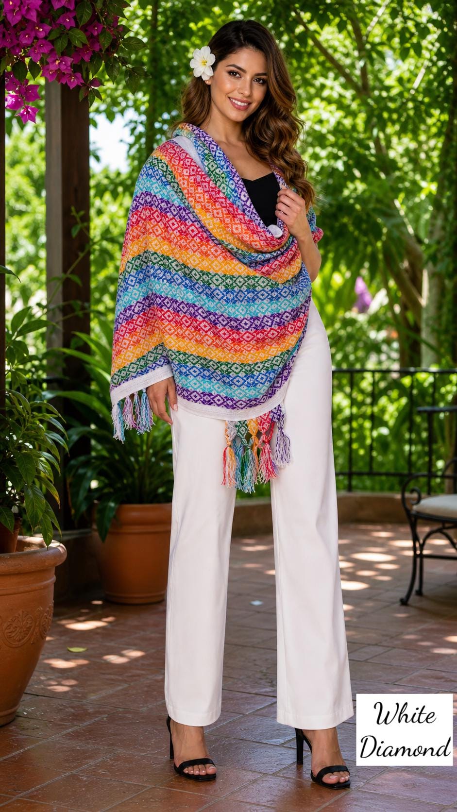 Image of May include: A colorful rainbow-striped shawl with diamond patterns and fringe. The shawl is draped over a person wearing white pants and a black top. The text "White Diamond" is visible in the image.